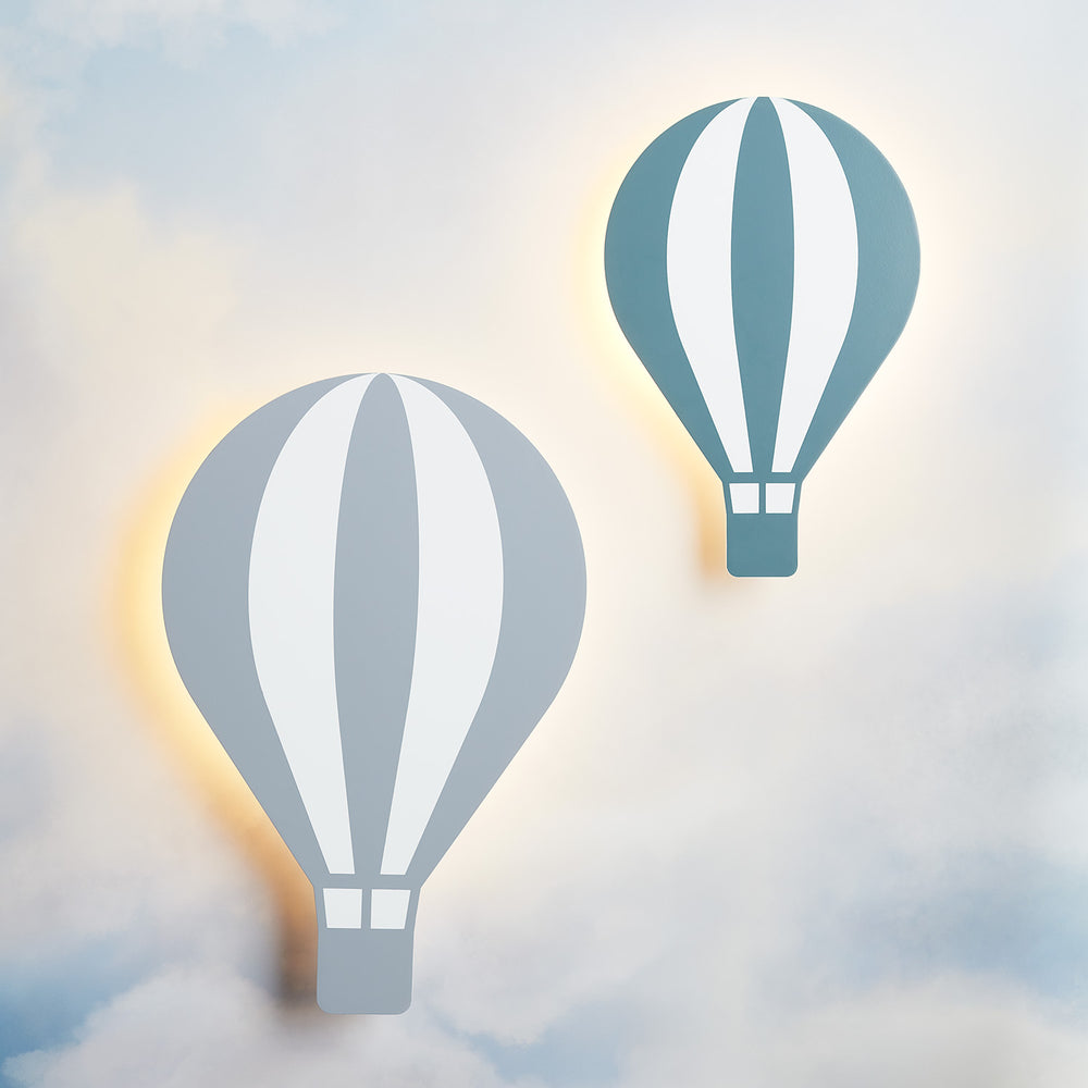 Zwei Heißluftballon-Wandlampen in Grau und Grün leuchten sanft an einer Wand mit Wolkenmotiv