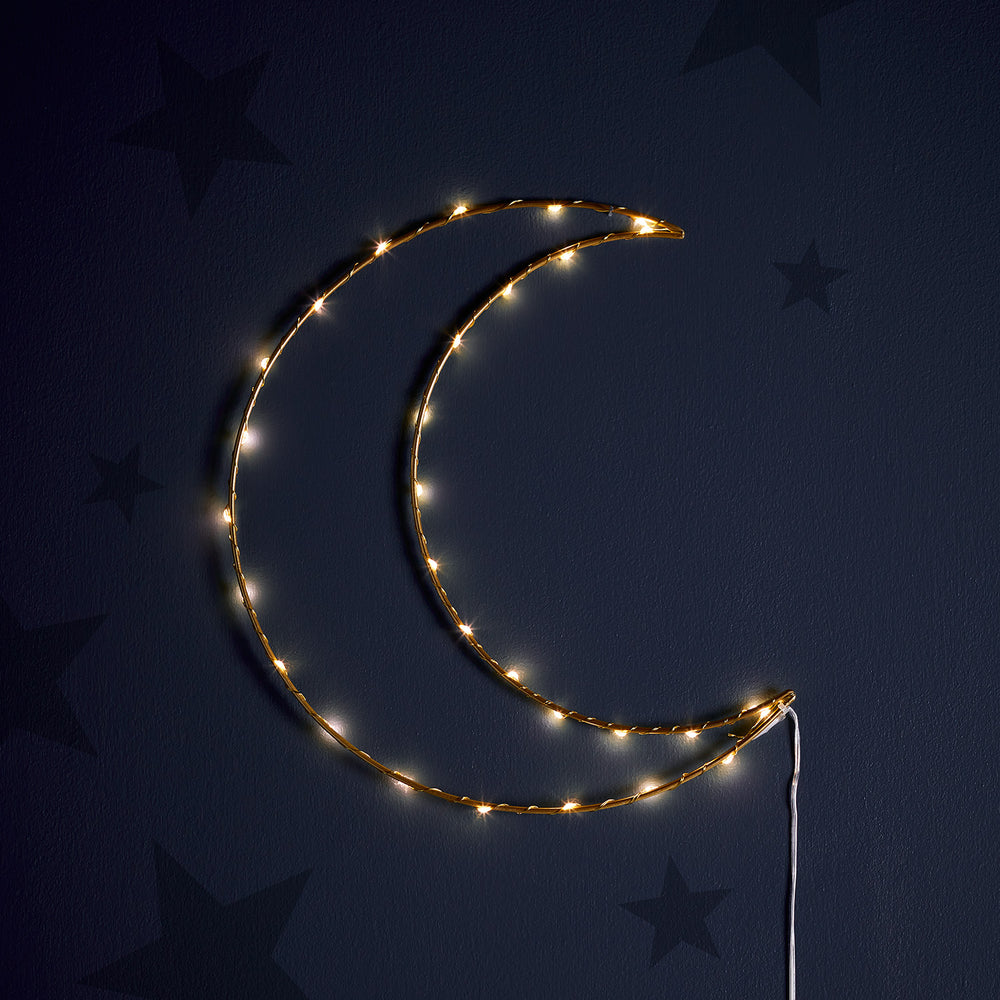 Leuchtender goldener LED-Mond an dunkler Wand mit Sternenmotiven im Hintergrund