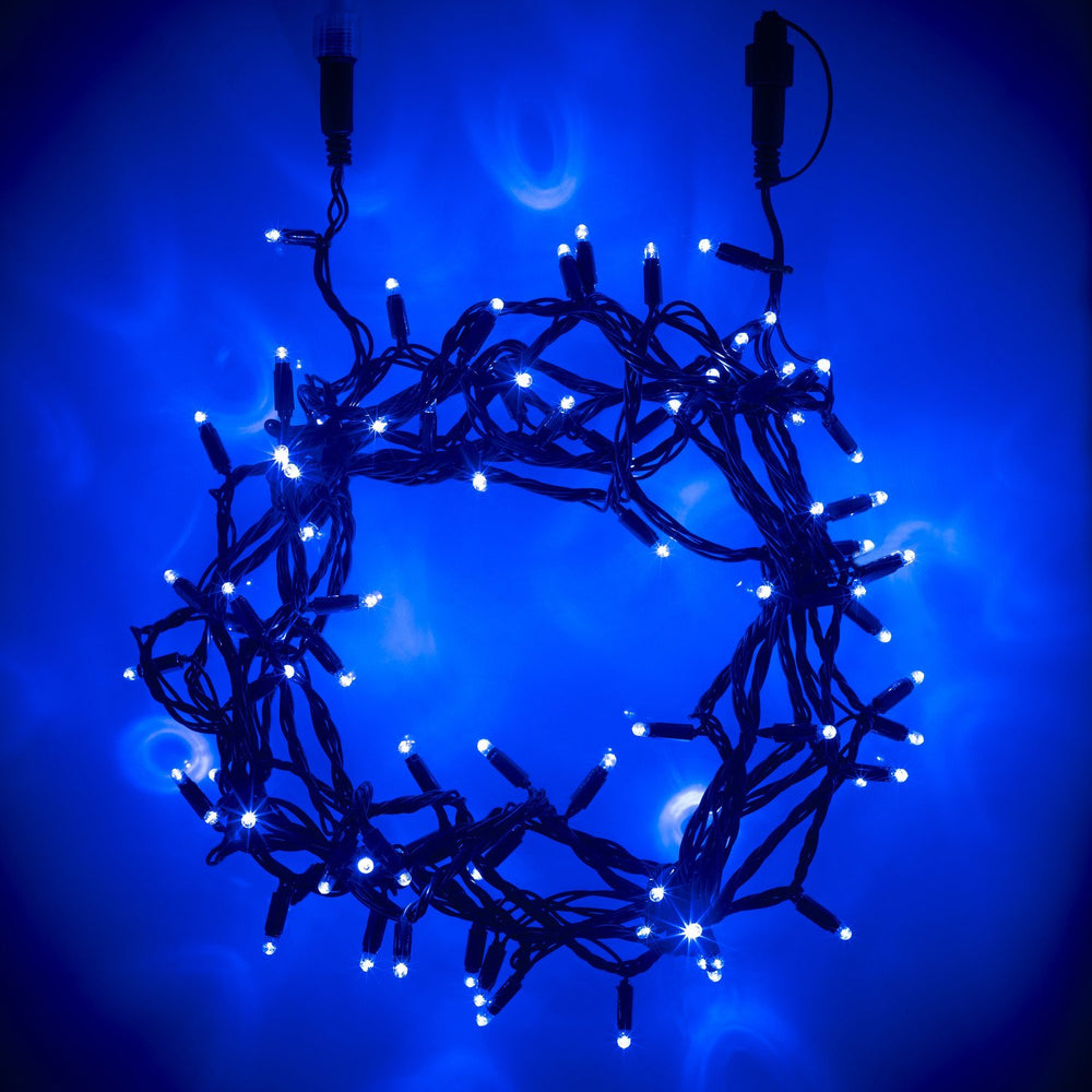 Blau leuchtende LED-Lichterkette mit grünem Kabel im Kreis angeordnet vor blauem Hintergrund