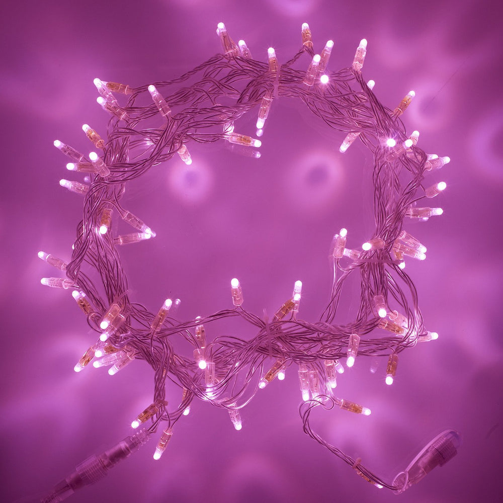 Runde pink leuchtende LED Lichterkette mit transparentem Kabel auf pinkem Hintergrund