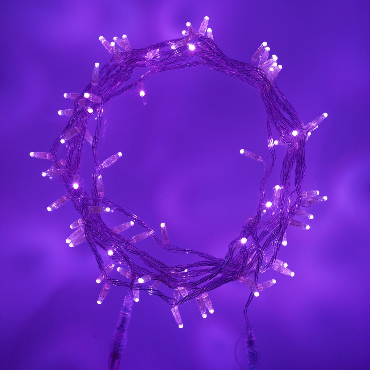 Lila leuchtende LED-Lichterkette mit transparentem Kabel auf lila Hintergrund