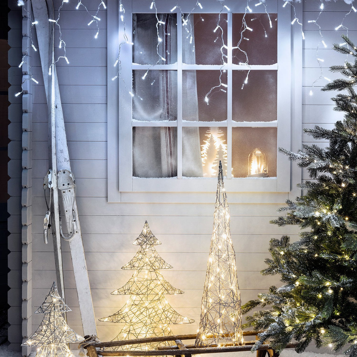 Winterliche Außendekoration mit Core Connect Eiszapfen Lichterkette an Fenster und beleuchteten Drahtbäumen