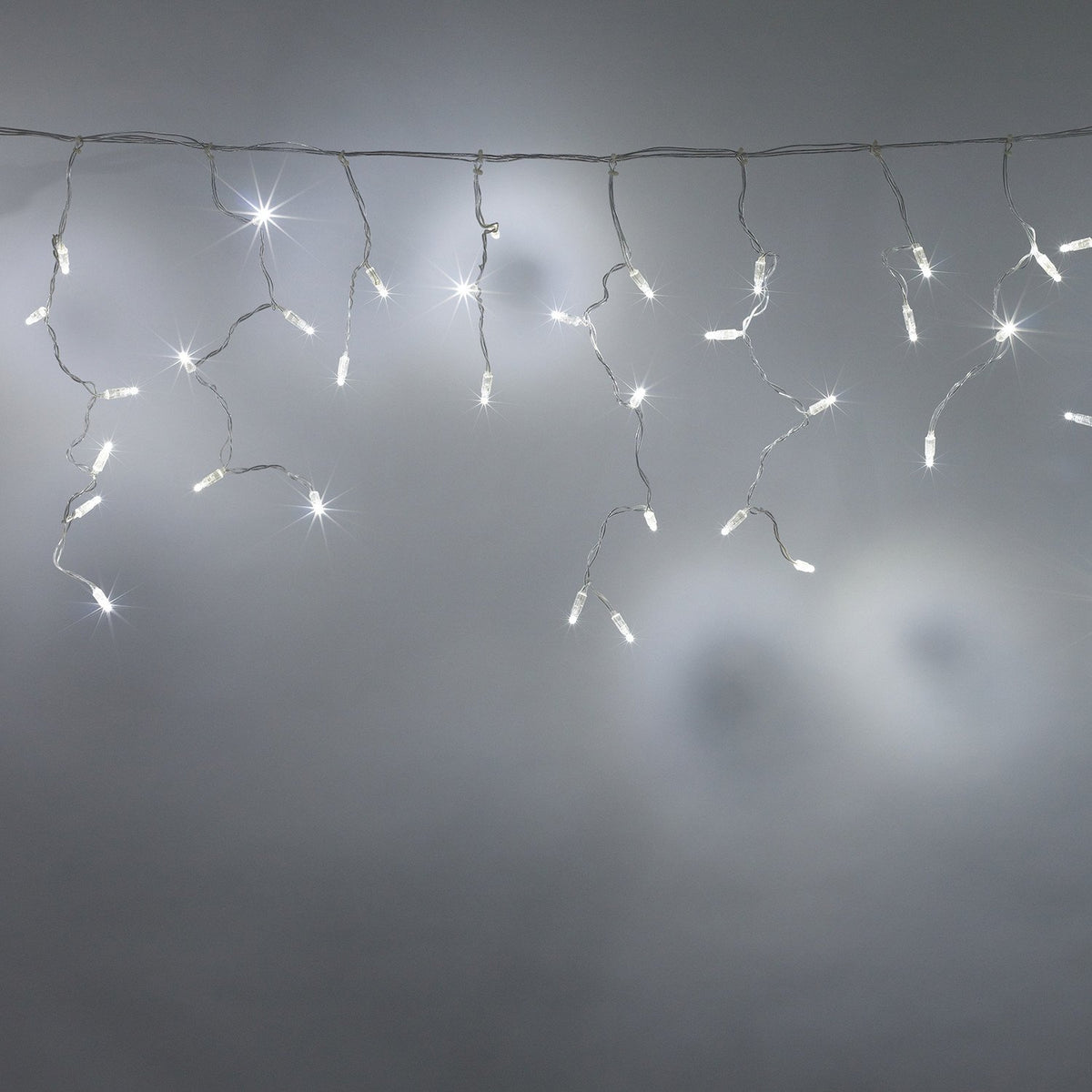 Weiße LED Eiszapfen Lichterkette mit transparentem Kabel vor grauem Hintergrund