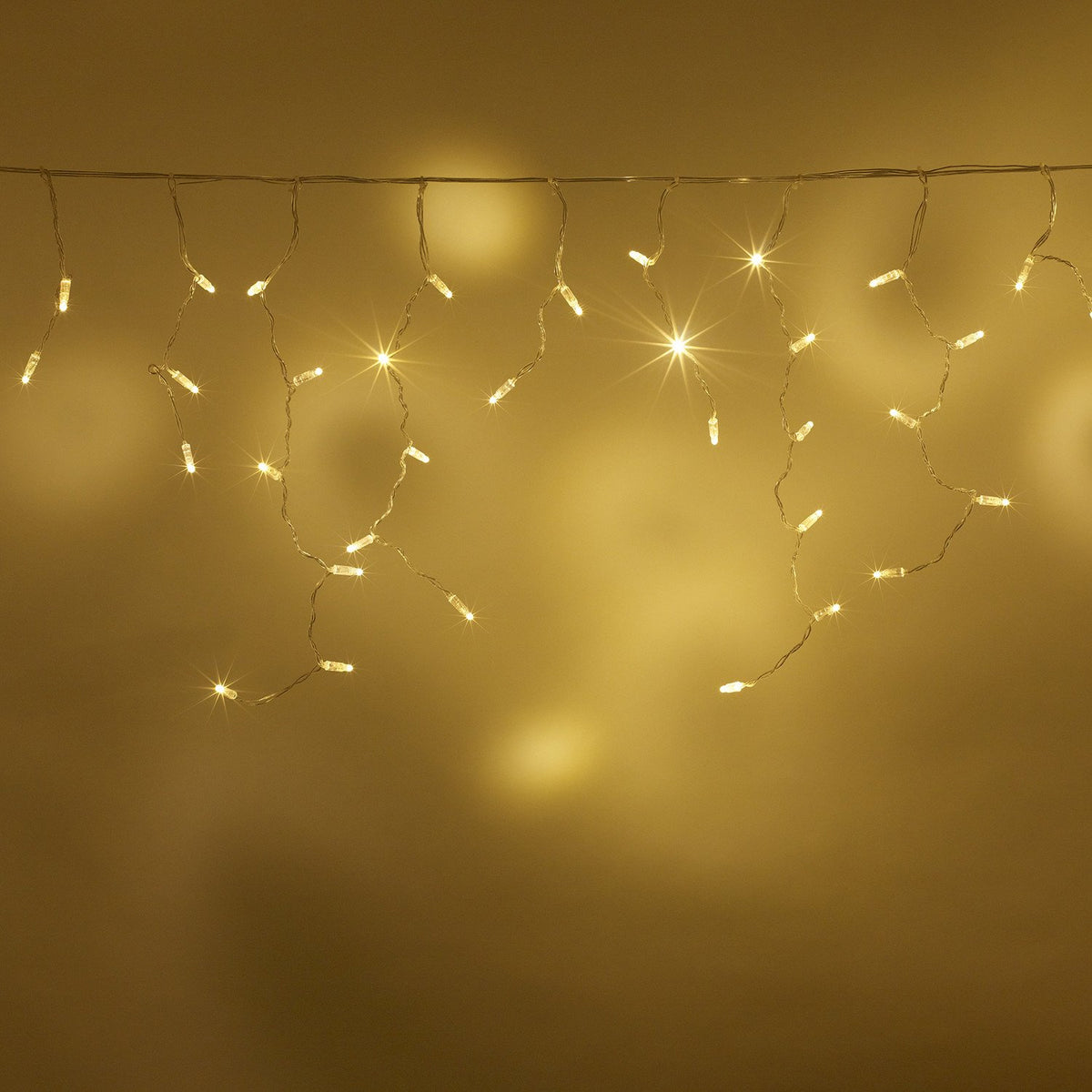 Warmweiße LED Eiszapfen Lichterkette vor gelbem Hintergrund