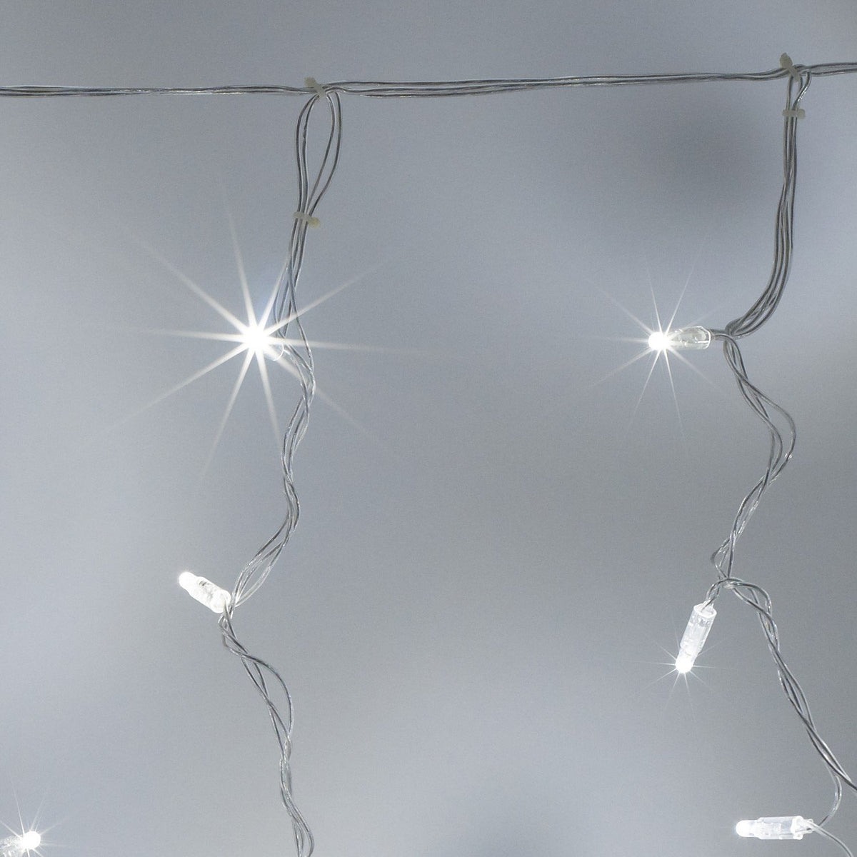 Nahaufnahme von weißen LED-Lichtern an transparentem Kabel des Lichtervorhangs