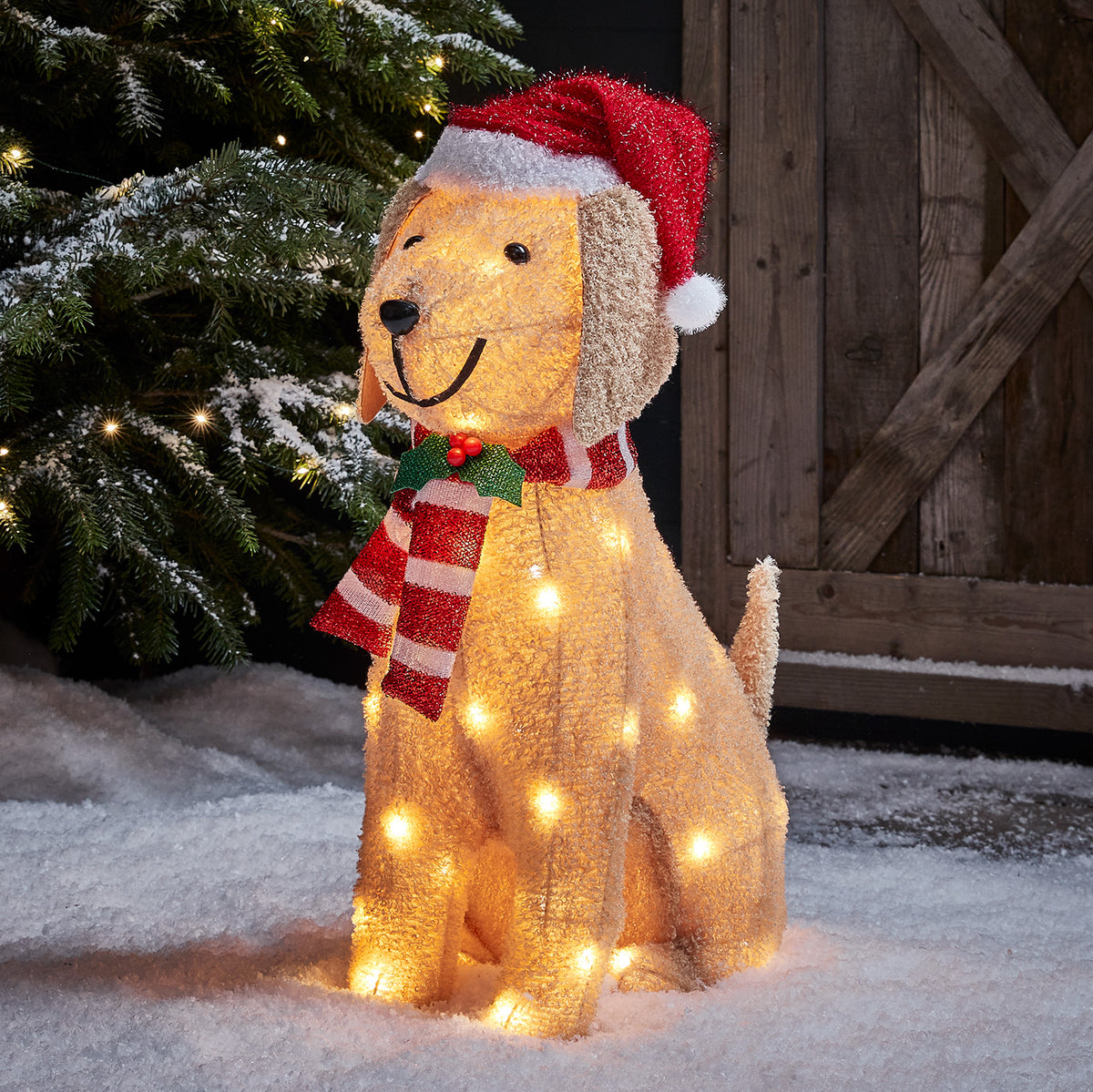 Leuchtende Weihnachtsfigur Labrador mit roter Mütze und rot-weißem Schal im Schnee