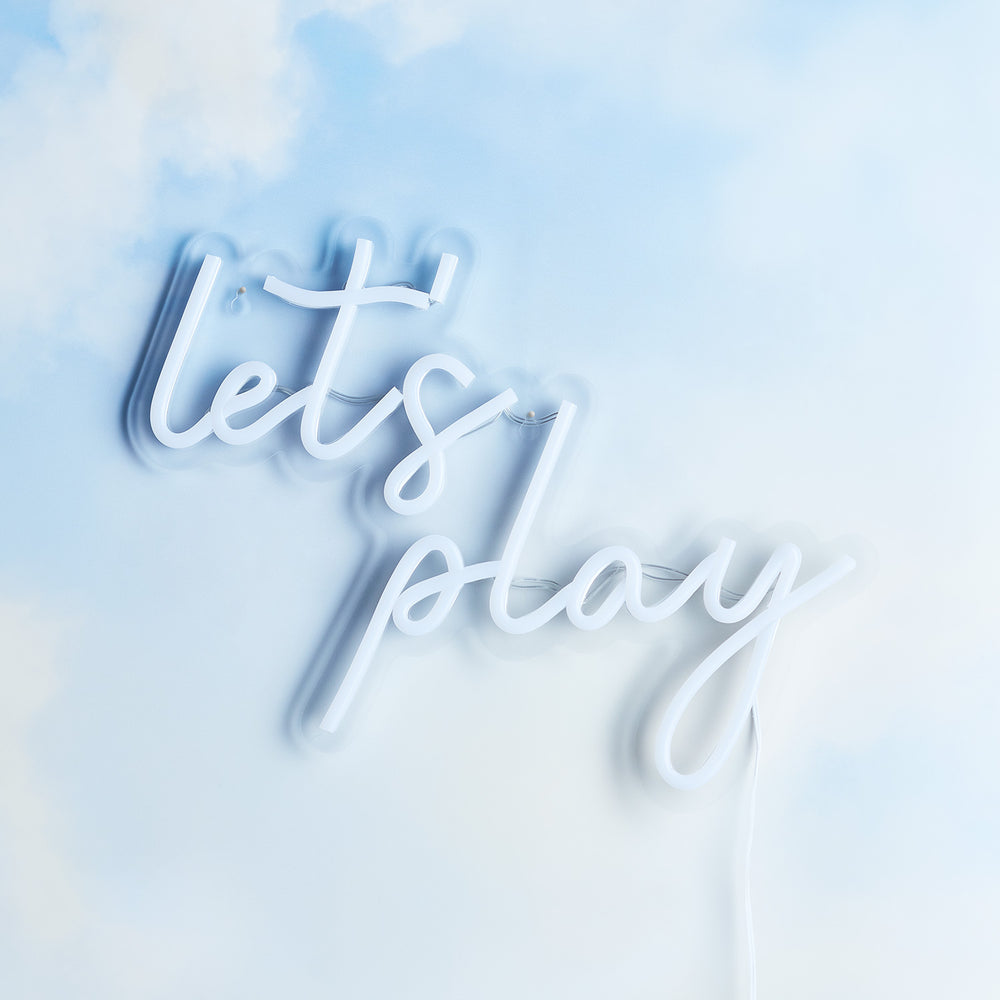 LED Neon Schriftzug 'Let's Play' ausgeschaltet an einer hellblauen Wand