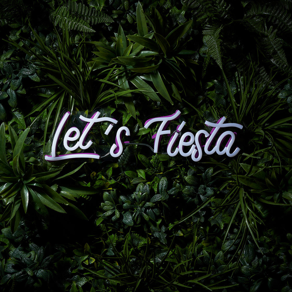 LED-Neonschriftzug Let's Fiesta inaktiv, weiße Schrift auf grünem Pflanzenhintergrund