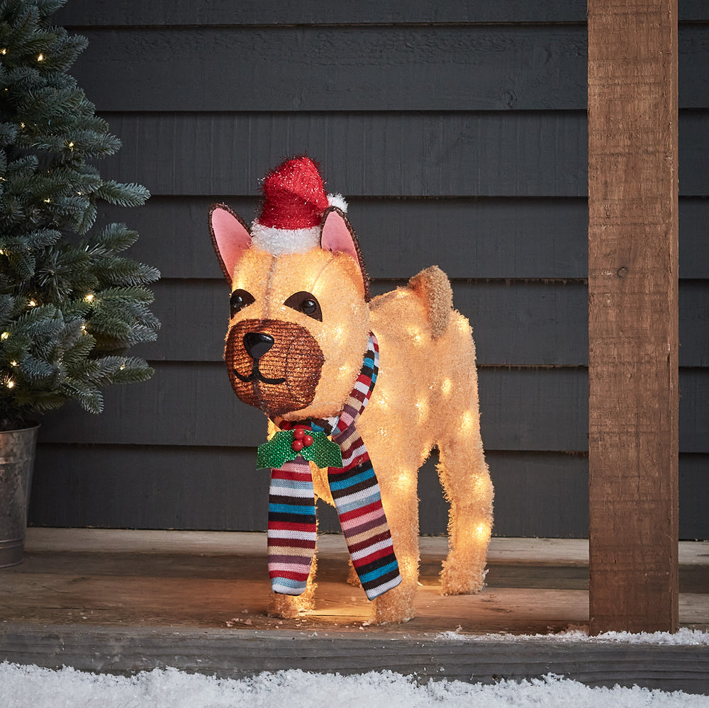 Leuchtende LED Weihnachtsfigur Bulldogge mit Mütze und Schal vor dunkler Hauswand im Außenbereich