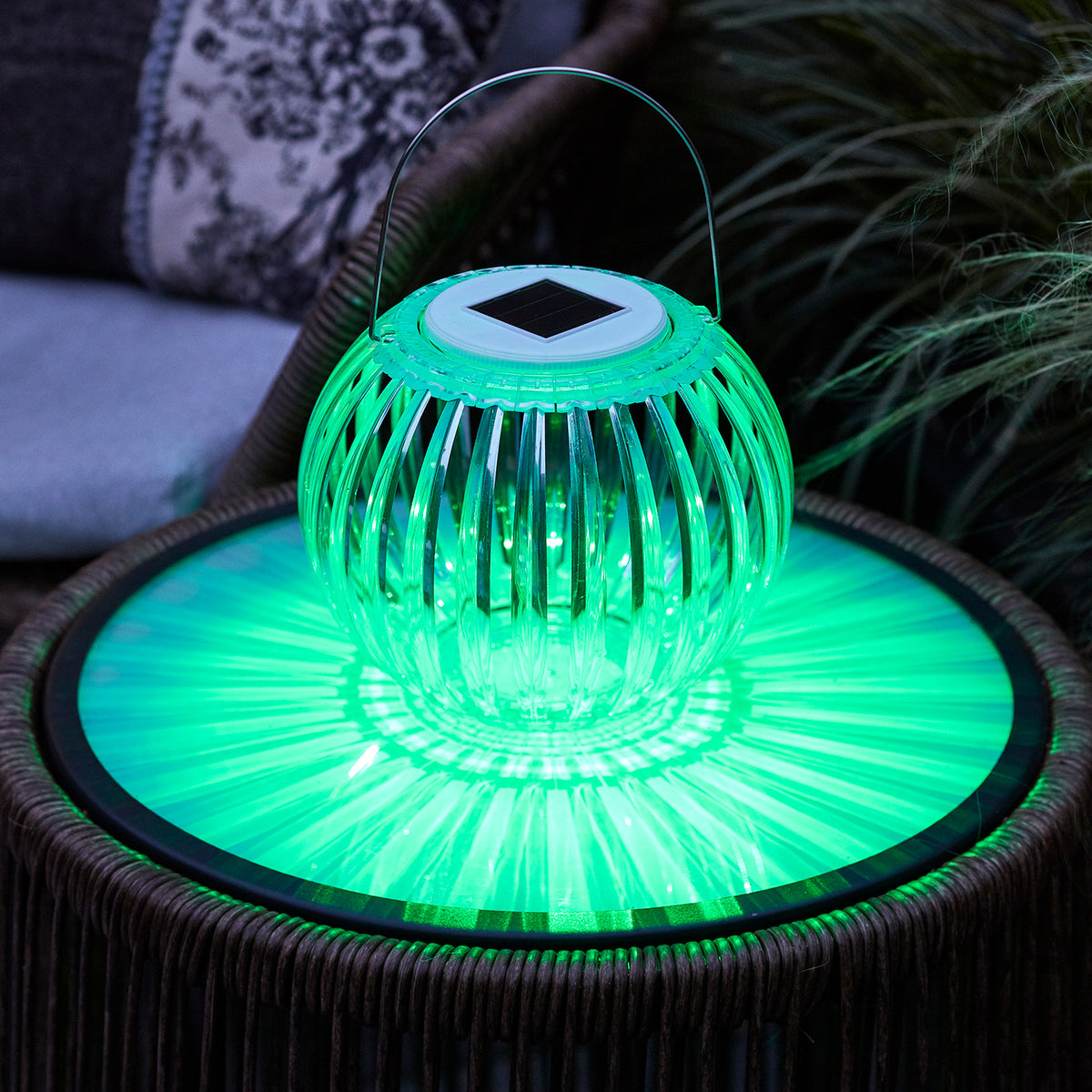Solar Hängeleuchte mit grünem Licht auf Gartentisch, transparente Acryllampe mit Henkel