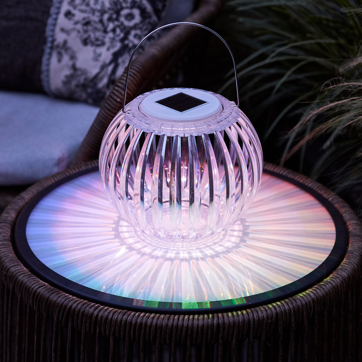 Solar Hängeleuchte mit pinkfarbenem Licht auf Gartentisch, Acryl mit Solarzelle oben