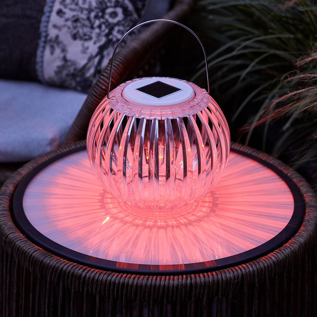 Solar Hängeleuchte mit rotem Licht auf Gartentisch, transparente Acryllampe mit Henkel