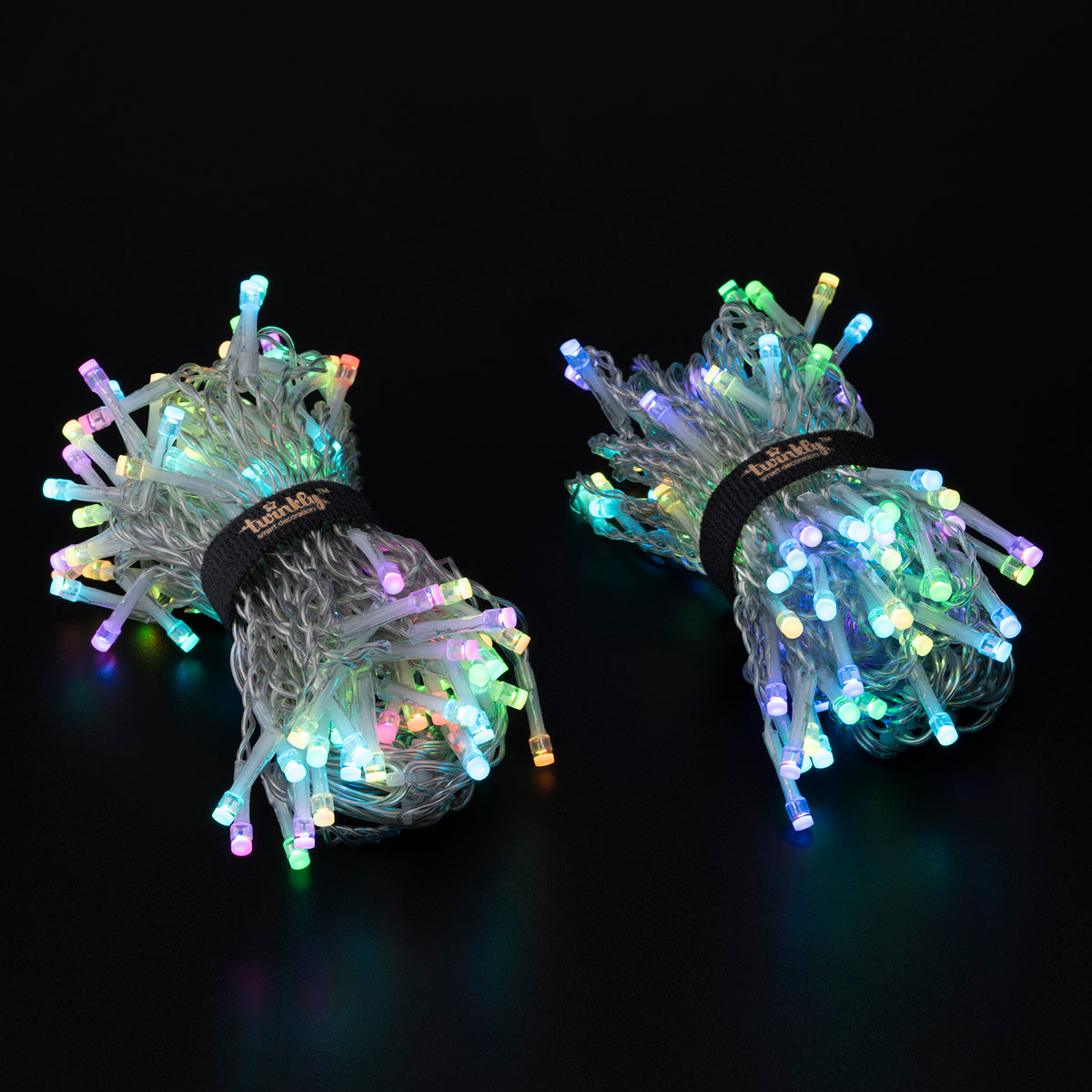 Zwei Bündel bunter LED-Lichterketten auf schwarzem Hintergrund