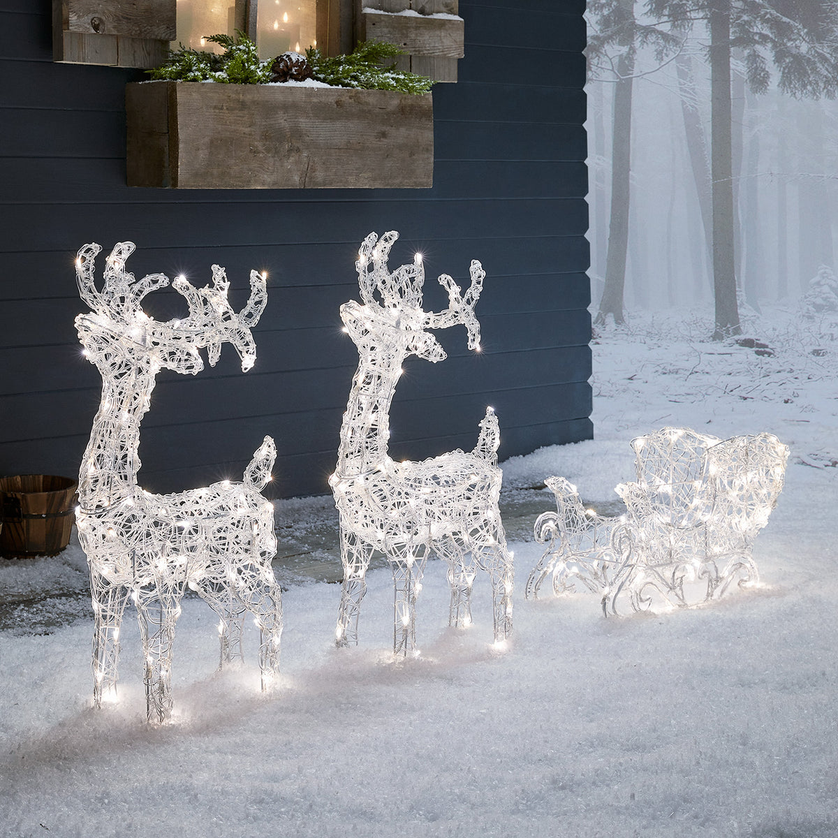 Weihnachtliche LED-Dekoration mit zwei Rentieren und Schlitten in warmweißem Licht im Schnee